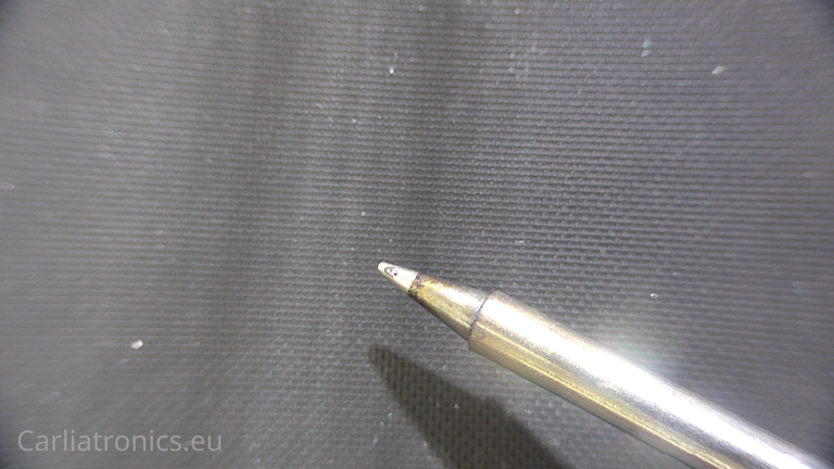 An image of a solder iron tip with a small solder bead on it